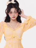 Close-up of the v-neckline and ruched front of the yellow tie-dye dress.