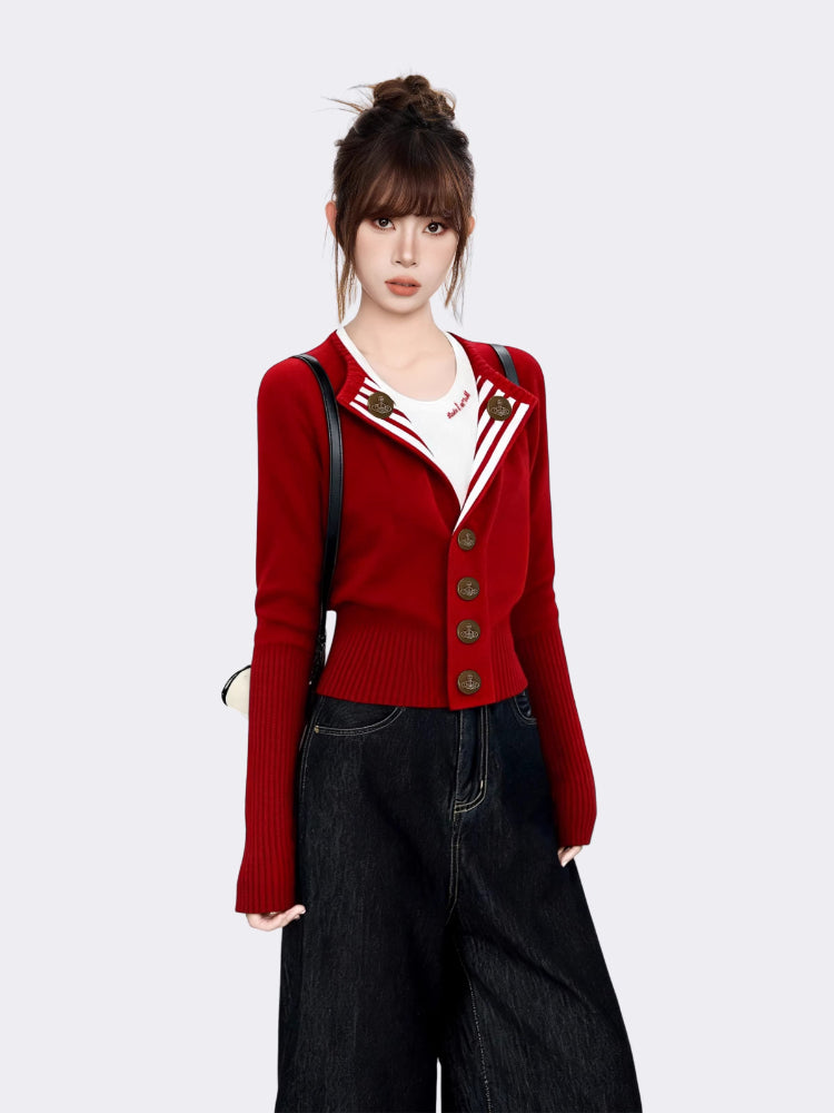 Close-up of red knit cardigan featuring striped lapel and bronze crest buttons