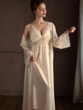 Woman wearing a cream-colored satin slip dress with lace trim and a matching long robe.
