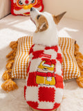 Back view of a corgi dog wearing a red and white checkerboard plush dog coat with embroidered brand logo and festive character.