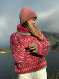 Woman in a pink floral knit turtleneck sweater smiling outdoors
