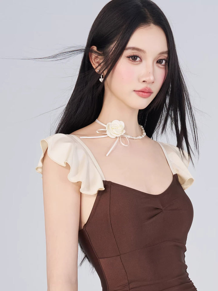 Close-up of the sweetheart neckline and flutter sleeves of the brown swimsuit.