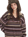 Close-up of a woman wearing a brown striped knit sweater with a v-neck and collar detail, and a brown faux fur hat with ear flaps.