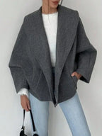 Front view of a grey wool blend oversized coat with welt pockets.