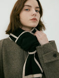 Model wearing a brown textured coat with a black and cream scarf tied around the neck