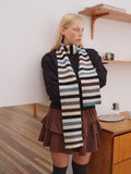 Striped scarf styled around neck in casual indoor setting