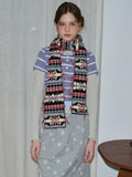 Woman wearing a patterned knit scarf with fringed edges.