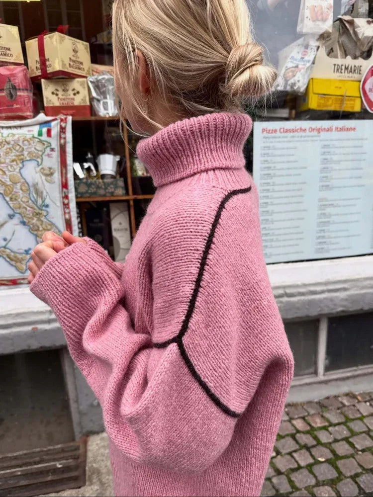 Side view of a woman in a pink knit sweater with a high turtleneck