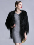 Front view of a woman in a black faux fur jacket and grey dress