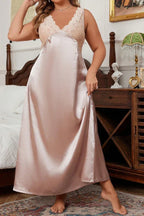 woman wearing a pink satin nightgown with lace details, standing and holding the hem