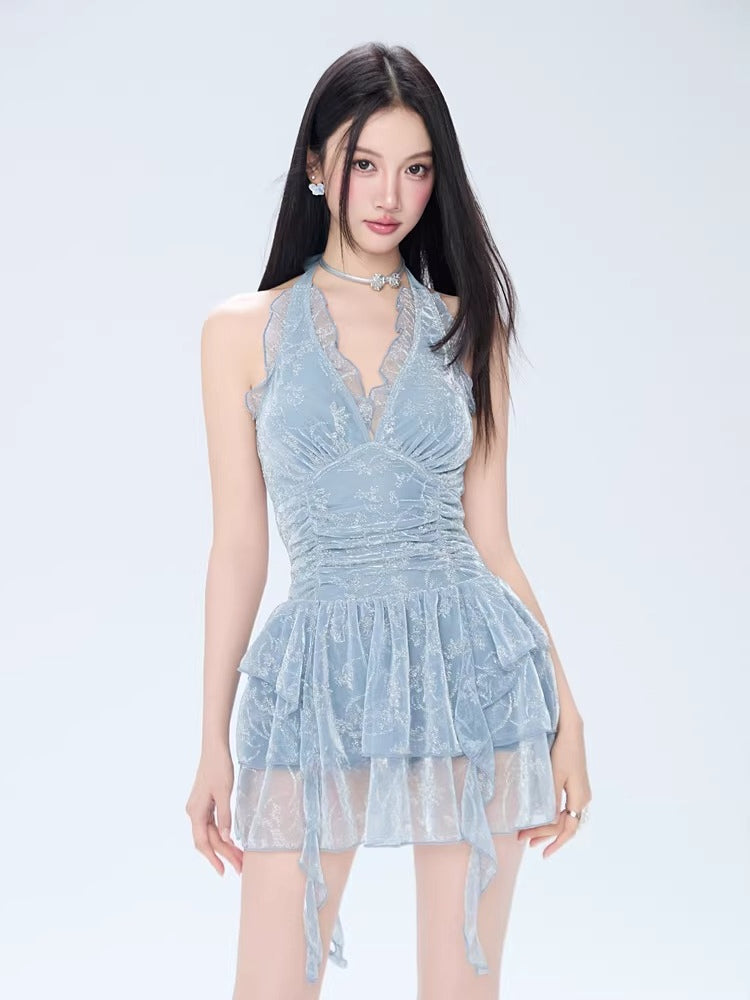 Woman wearing a light blue lace halter neck mini dress with a ruched bodice and tiered skirt.