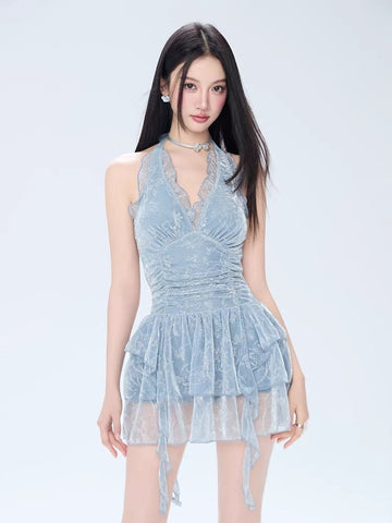 Woman wearing a light blue lace halter neck mini dress with a ruched bodice and tiered skirt.