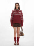 Woman wearing a red knit sweater with a white Fair Isle pattern and a button placket.