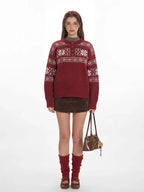 Woman wearing a red knit sweater with a white Fair Isle pattern and a button placket.