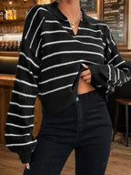 Woman wearing a black and white striped cropped knit sweater with a collared neckline and long sleeves.