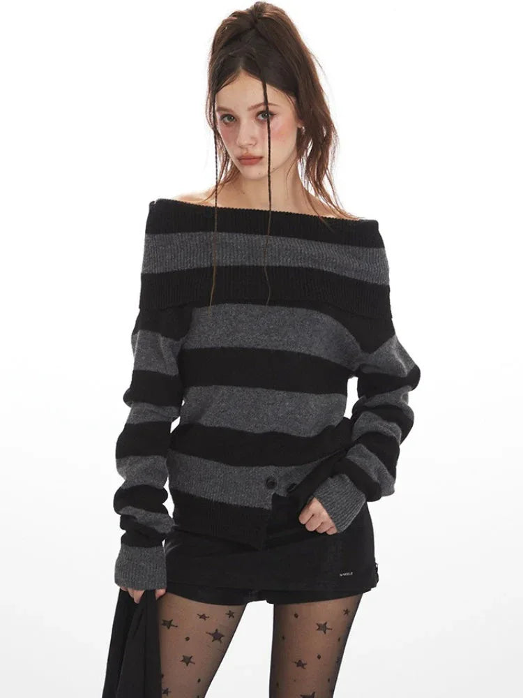 Woman wearing a grey and black striped knit sweater styled off-the-shoulder, black shorts, black patterned tights, and black boots.