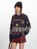 Close-up of a woman wearing a navy blue knit sweater with a detailed Fair Isle pattern.