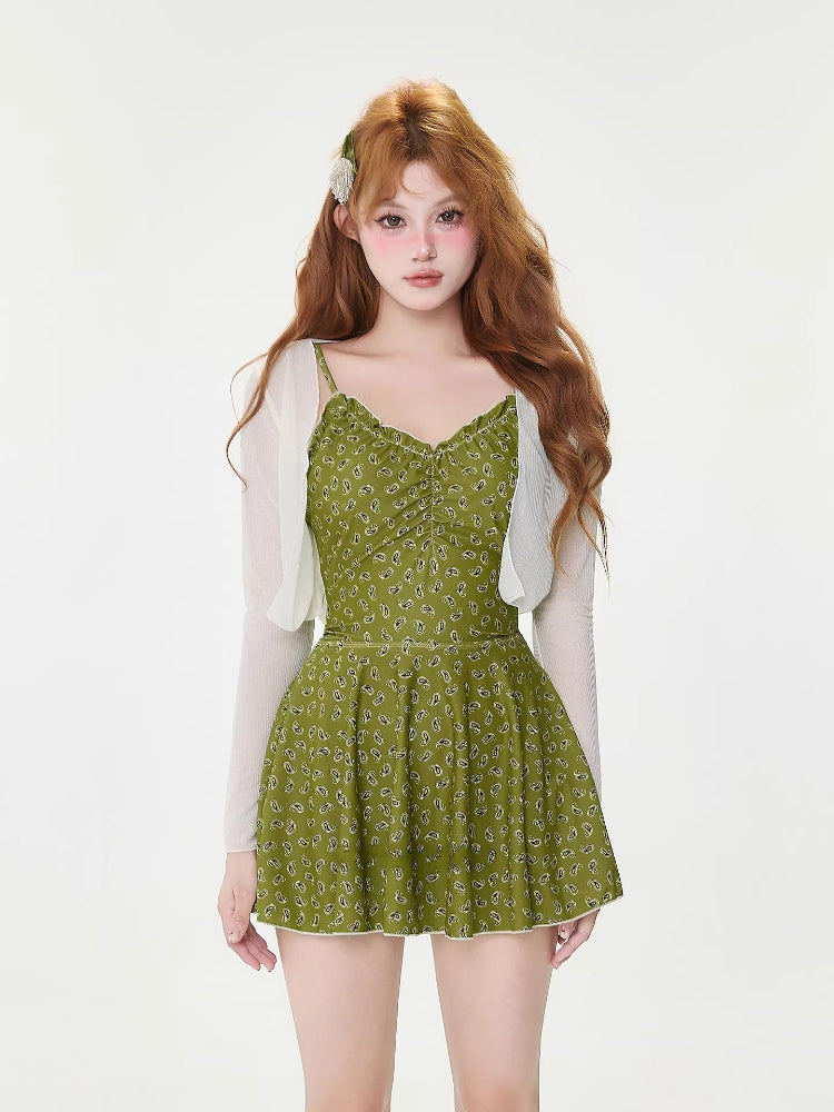 Woman wearing a green paisley print one-piece swimsuit with shorts and ruffled hem
