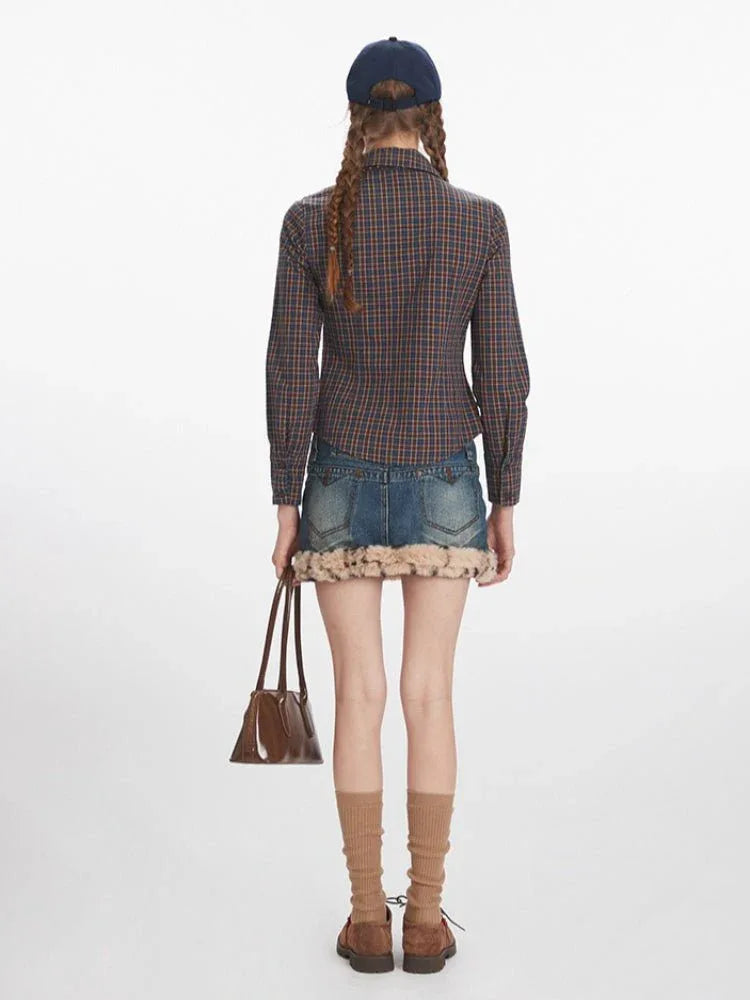 Back view of a woman in a plaid shirt and denim skirt with fur trim, holding a brown handbag.