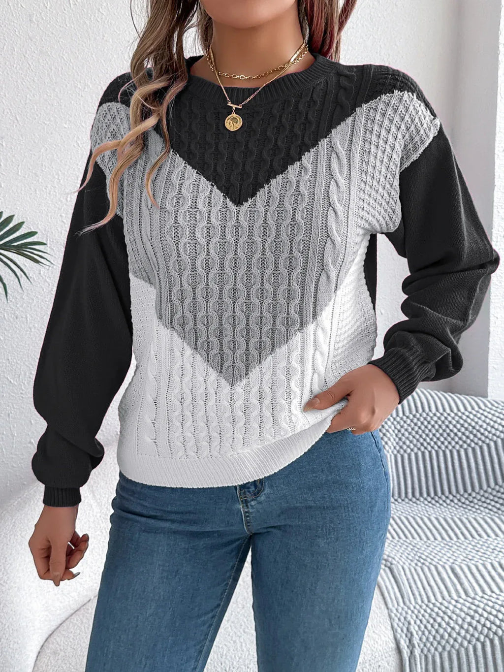 Front view of a woman styling a color block sweater with accessories.