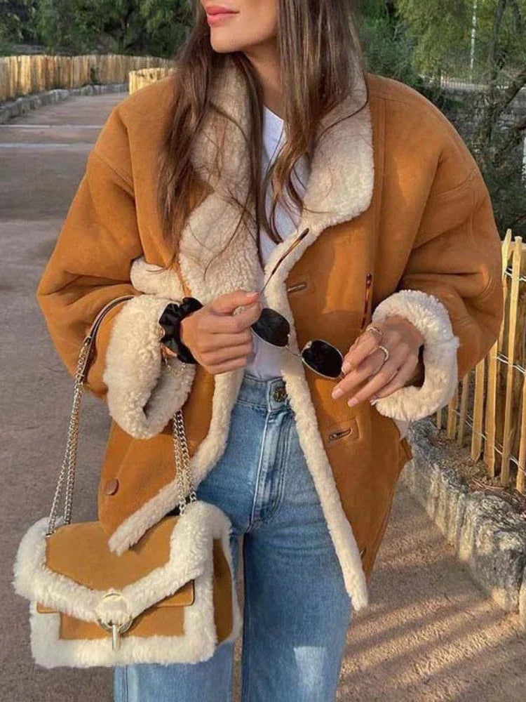 Woman in a faux suede and shearling aviator jacket paired with jeans.