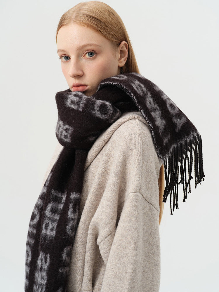 Close-up of a woman wearing a black scarf with white text and fringe