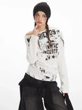 Close-up of a woman wearing a white long-sleeve graphic print top with an off-the-shoulder design.