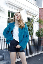 Woman posing in a teal faux fur jacket outdoors