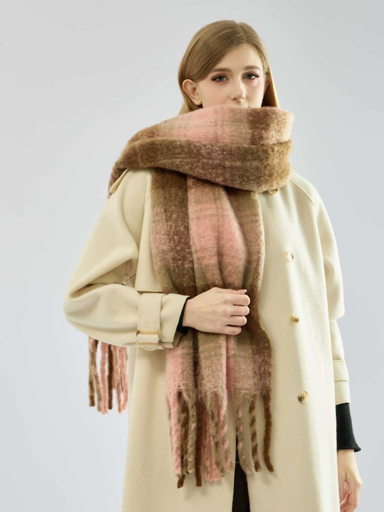 Close-up of a woman wearing a thick, plaid scarf with fringe detail.