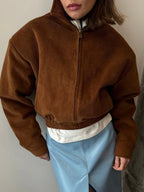 Front view of a brown corduroy bomber jacket with elasticated hem.