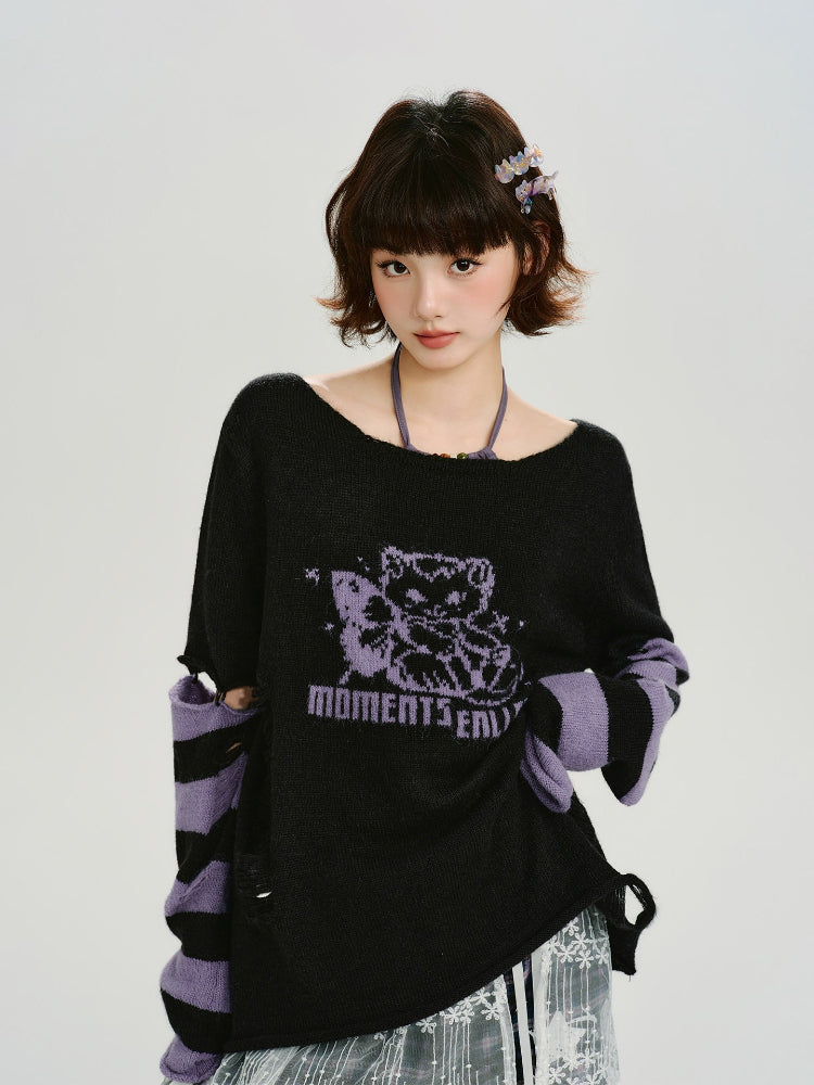 Woman wearing a black oversized knit sweater with a purple graphic print and distressed details.