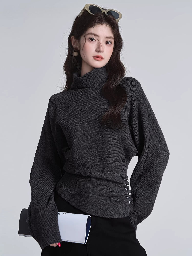Model posing in a dark grey high neck knit sweater