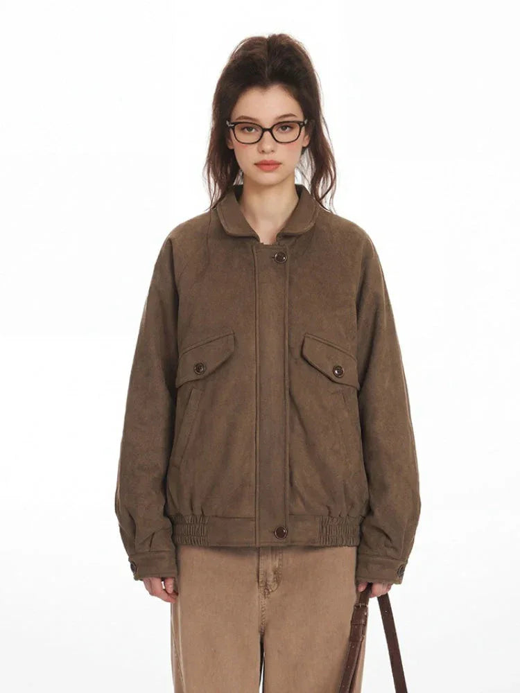 Front view of a woman in a brown textured bomber jacket, showcasing its collared design and chest pockets.
