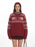 Close-up of a woman wearing a red knit sweater with a white Fair Isle pattern and a button placket.