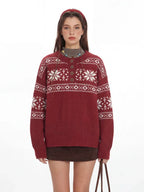 Close-up of a woman wearing a red knit sweater with a white Fair Isle pattern and a button placket.