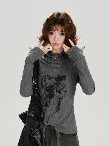 Model wearing a grey long-sleeve graphic print turtleneck top with cinched hem and thumbholes