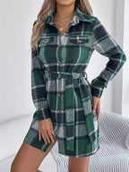 Woman wearing a green plaid flannel shirt dress with a tie waist.