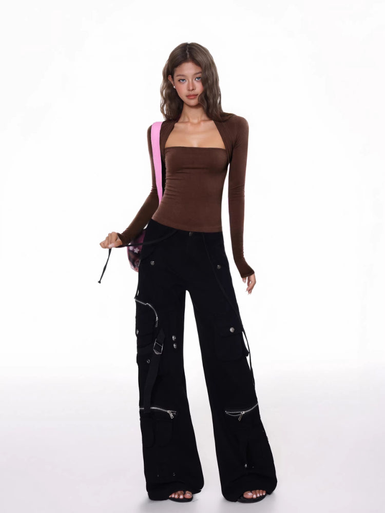 Full body shot of a woman in a brown long-sleeve square neck top and black cargo pants, carrying a pink tote bag.