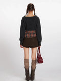 Back view of a model in a dark grey knit cropped sweater and a brown mini skirt.
