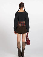 Back view of a model in a dark grey knit cropped sweater and a brown mini skirt.