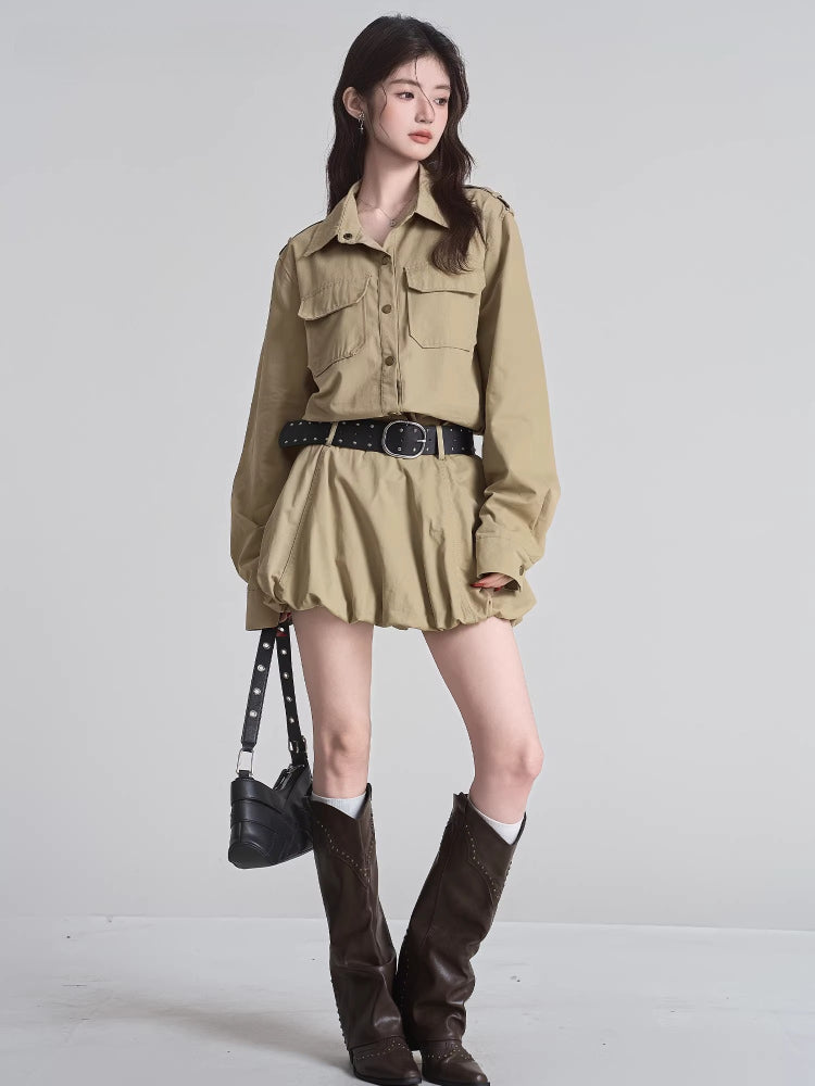 Woman wearing a khaki shirt dress with button-down front and chest pockets.