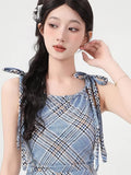 Close-up of the square neckline and tie shoulder straps on a blue plaid dress