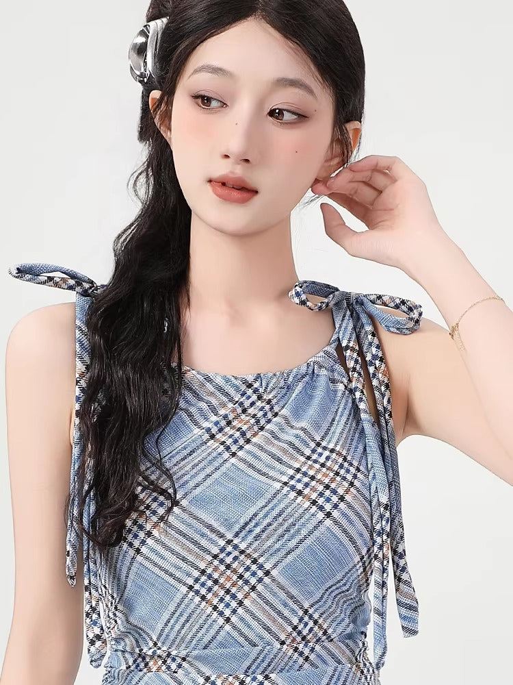 Close-up of the square neckline and tie shoulder straps on a blue plaid dress