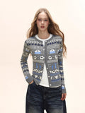 Woman wearing a grey button-down cardigan with a Fair Isle knit pattern and white t-shirt.
