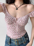 Front view of a woman's torso showing a pink floral print top with a sweetheart neckline and tie closure.