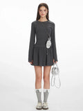Model wearing a dark grey ribbed drop waist mini dress with long sleeves and crew neckline.