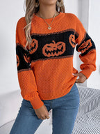 Woman wearing an orange and black striped knit sweater with pumpkin graphics.