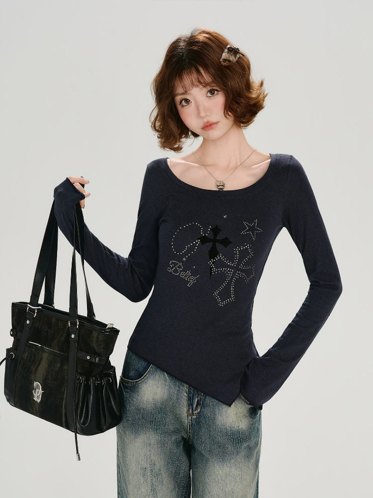 Woman posing with a black handbag while wearing a dark blue long-sleeve graphic t-shirt