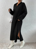 Model wearing a black ribbed knit midi dress with a pointed collar and v-neck, featuring long sleeves and a side slit.