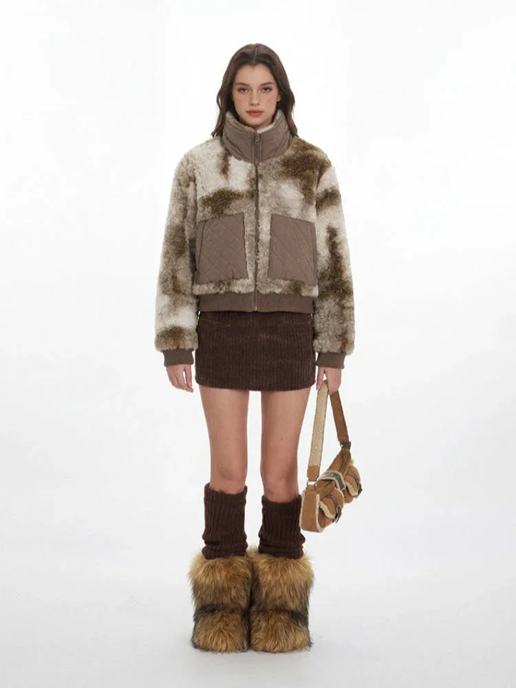 Woman wearing a brown and cream abstract print faux fur bomber jacket with quilted pockets